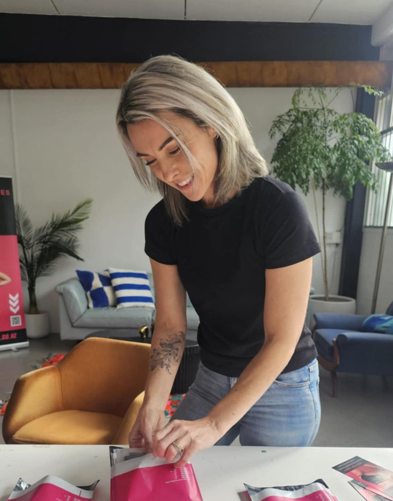 Suzanne Brown owner of Squaties packing seamless underwear orders into bright pink courier bags