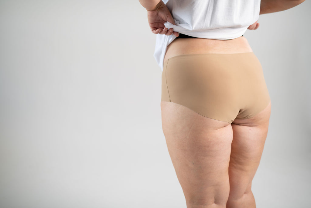 Woman wearing Squaties Seamless Classic Briefs in nude colour, facing away.