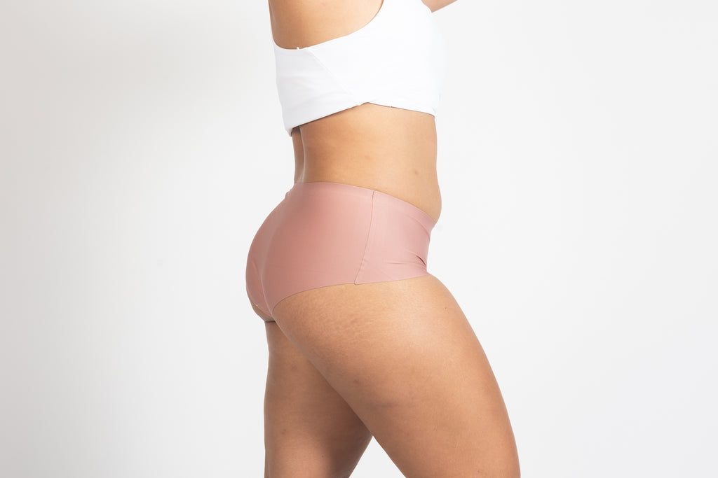 Model in pink seamless briefs and white crop top